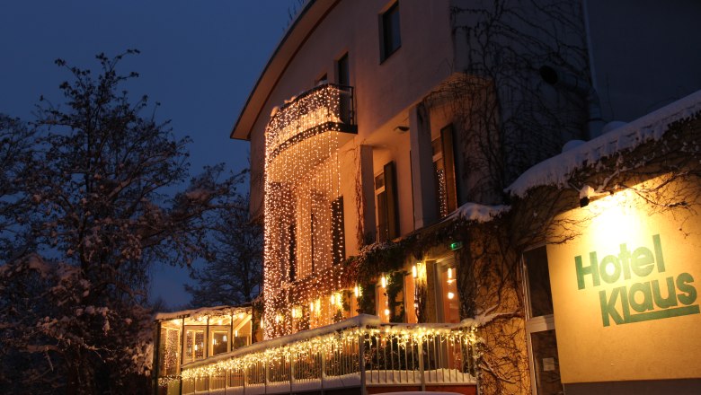 Ein beleuchtetes Hotelgeb&auml;ude mit Lichterketten dekoriert.